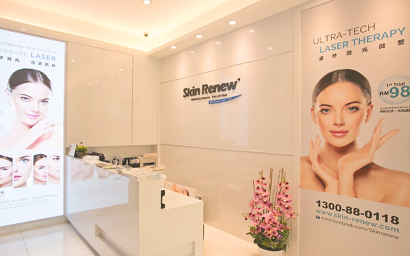 Entrance of Skin Renew's Beauty Center showing front desk and promotional banners of beauty therapies.